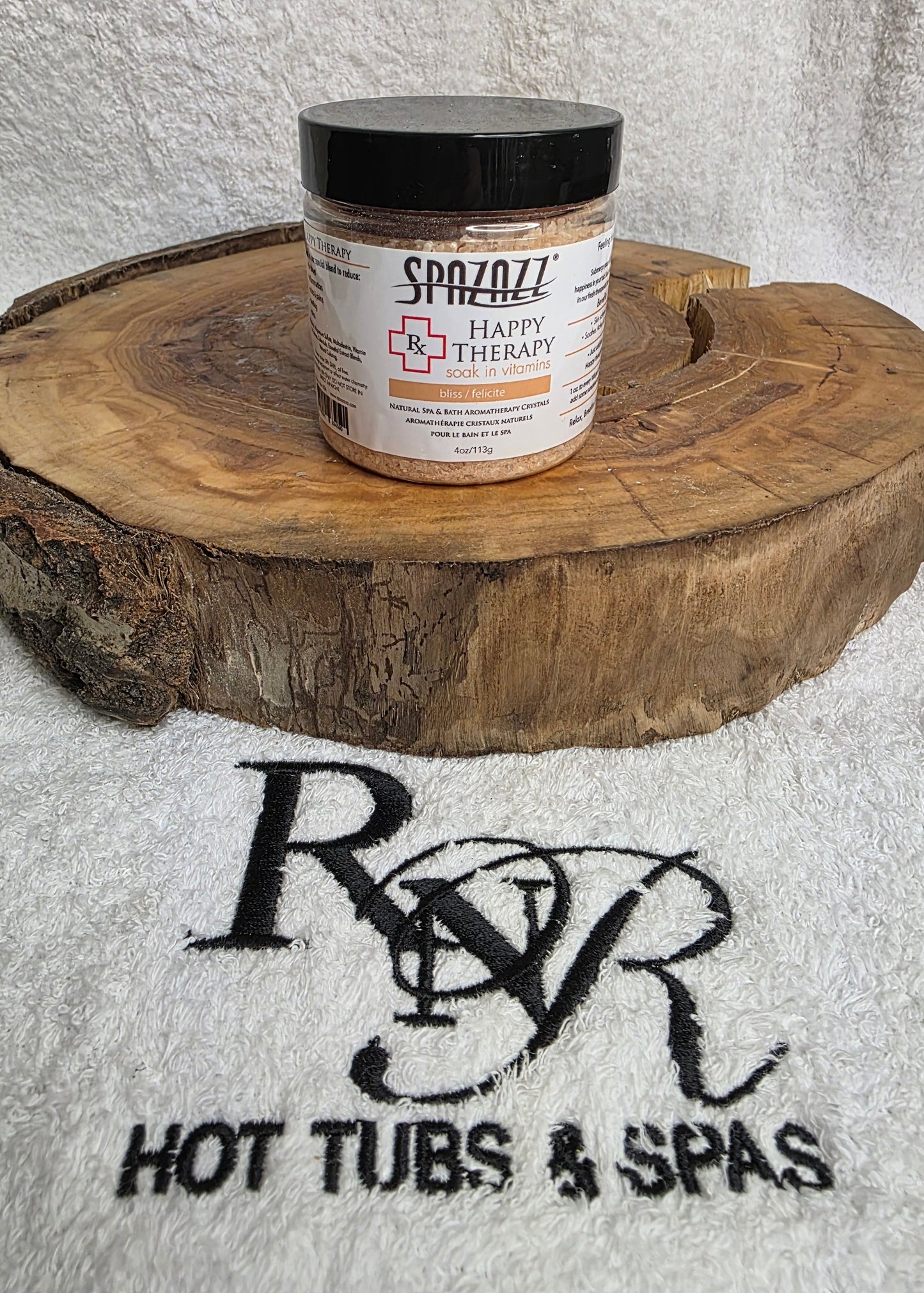 Jar of Spazazz Happy Therapy aromatherapy crystals on a wooden block with RnR Hot Tubs and Spas logo in the background