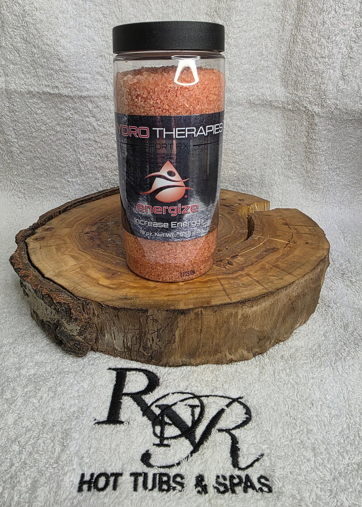 Bottle of Hydro Therapies on a wooden block with RnR Hot Tubs & Spas logo in the background
