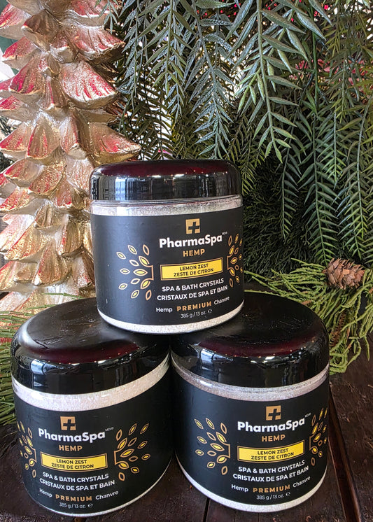 Three jars of PharmaSpa product on a reflective surface with greenery in the background