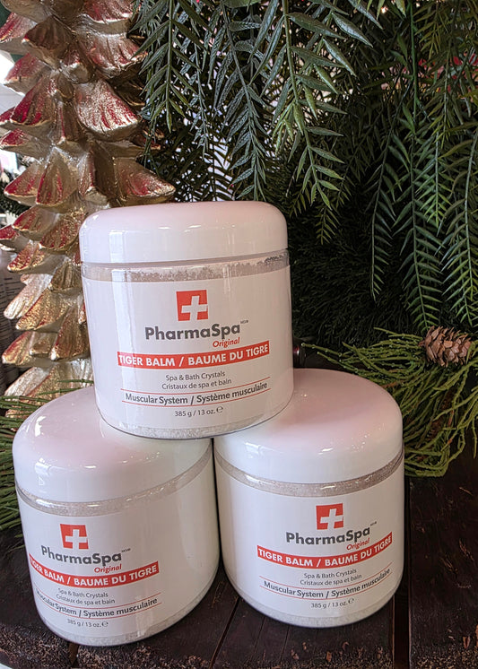 Three containers of Pharmaspa product on a wooden surface with greenery in the background