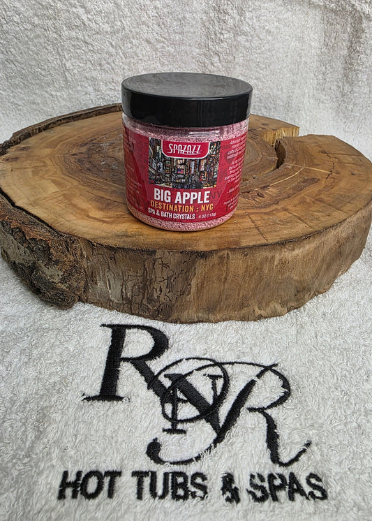 Spazazz Destinations Big Apple aromatherapy crystals on a wooden block with RnR Hot Tubs & Spas branding in the background.