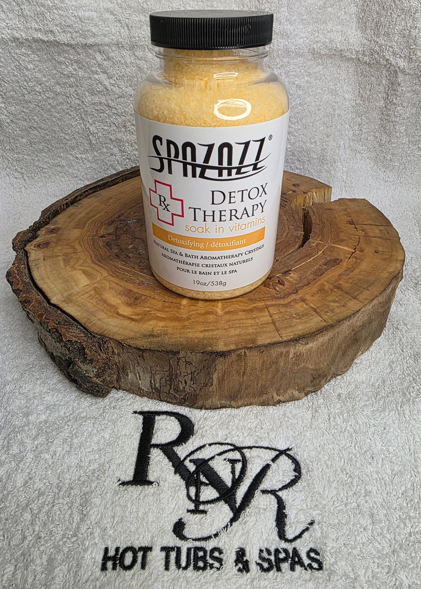 SpaZazz Detox Therapy product on a wooden block with RnR Hot Tubs & Spas branding in the background.
