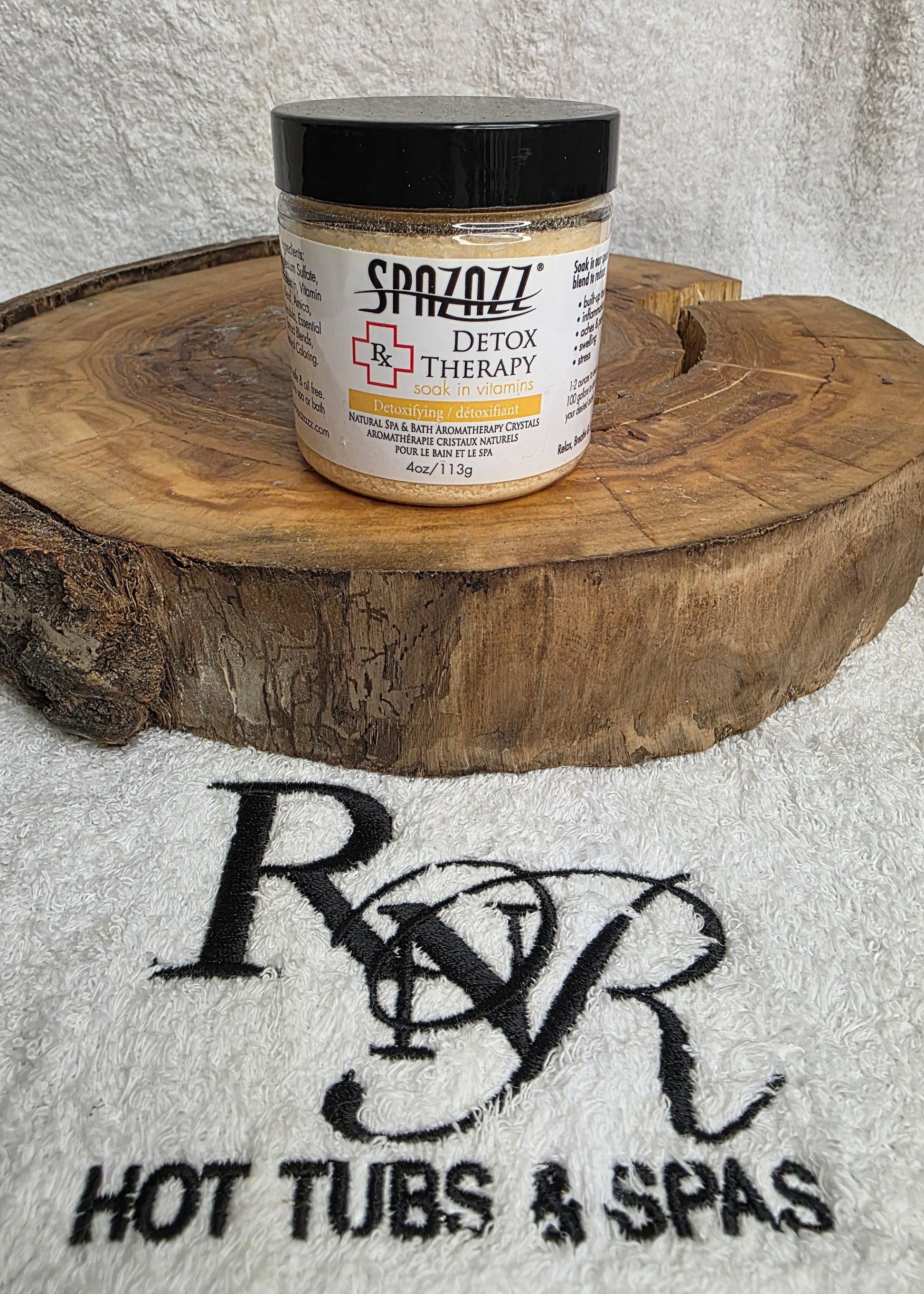 Jar of Spazazz Detox aromatherapy crystals on a wooden block with RnR Hot Tubs & Spas logo in the background