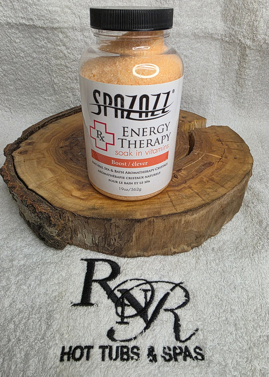 Bottle of Spazazz Energy Therapy aromatherapy crystals on a wooden block with a towel featuring RnR Hot Tubs & Spas logo in the background.