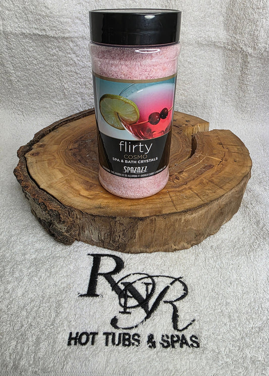 Bottle of Flirty Aromatherapy Crystals on a wooden block with RnR Hot Tubs & Spas branding in the background.