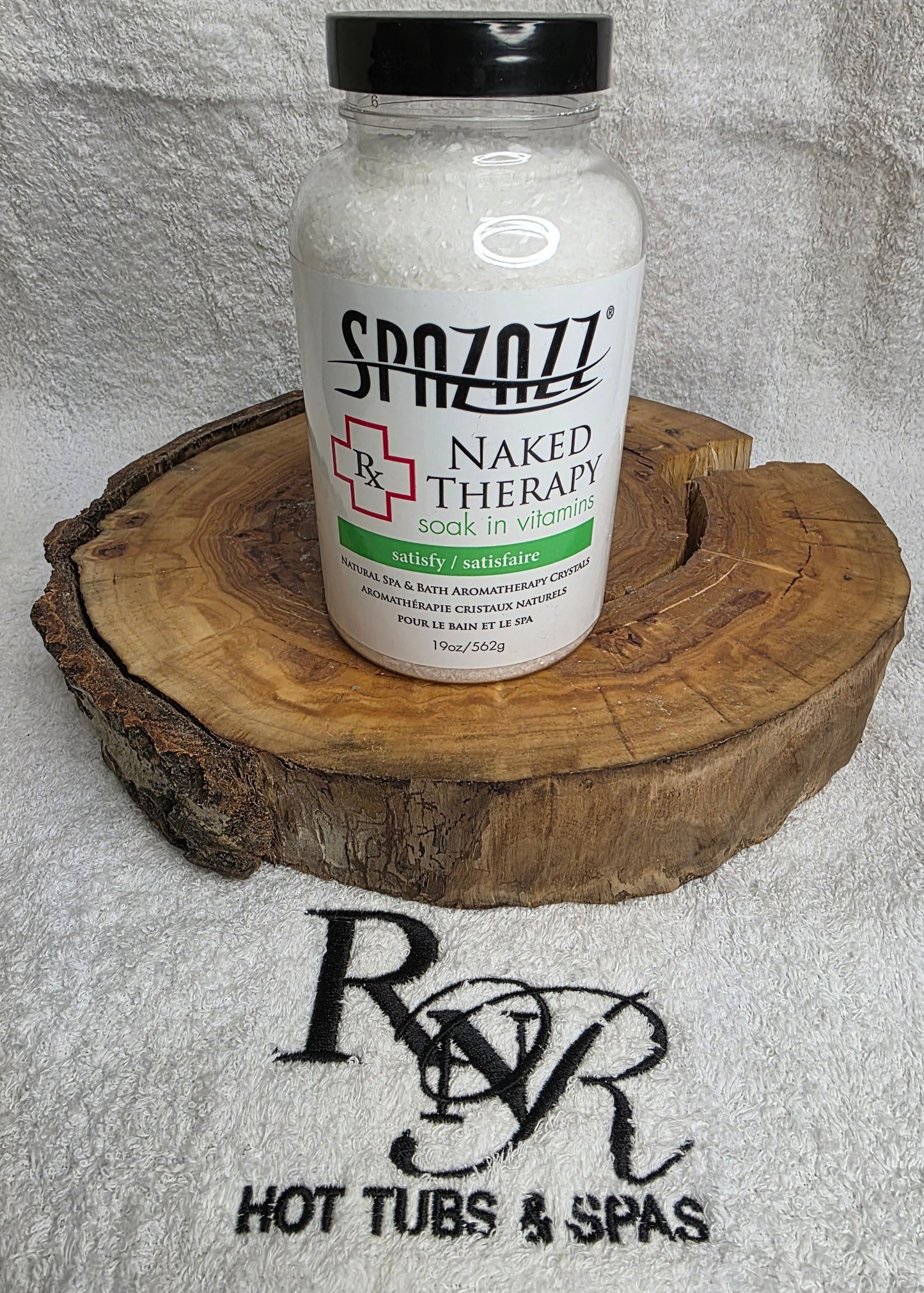 Bottle of Spazzazz Naked Therapy on a wooden block with RnR Hot Tubs & Spas logo in the background