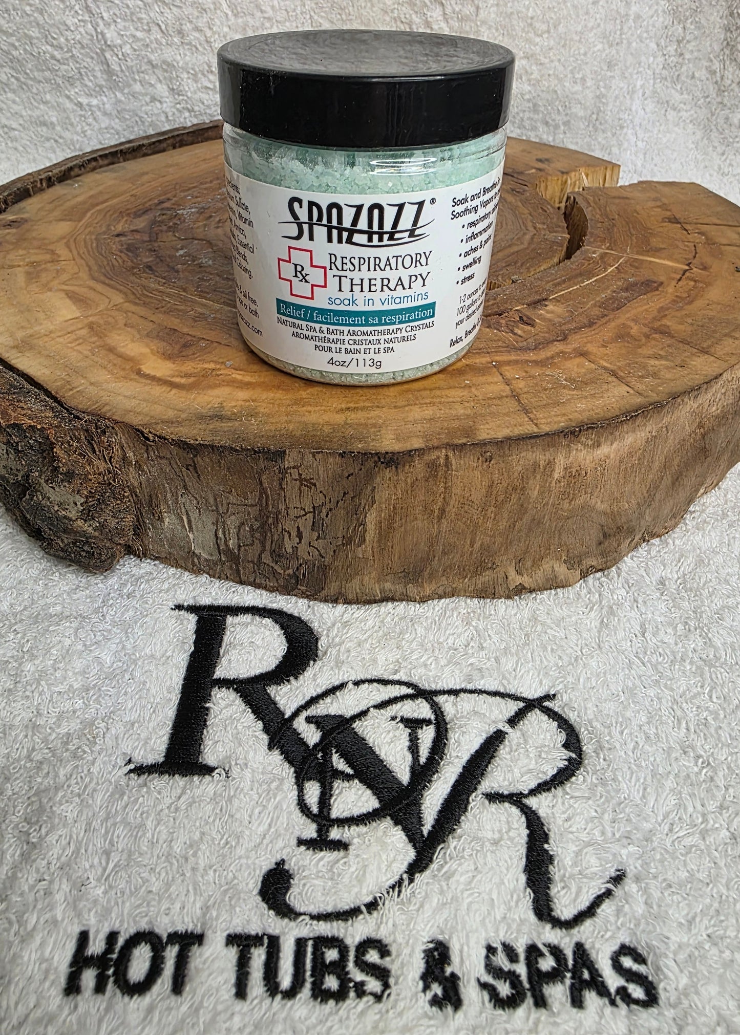 Container of Spazazz Respiratory Therapy aromatherapy crystals on a wooden block with RnR Hot Tubs & Spas logo in the background