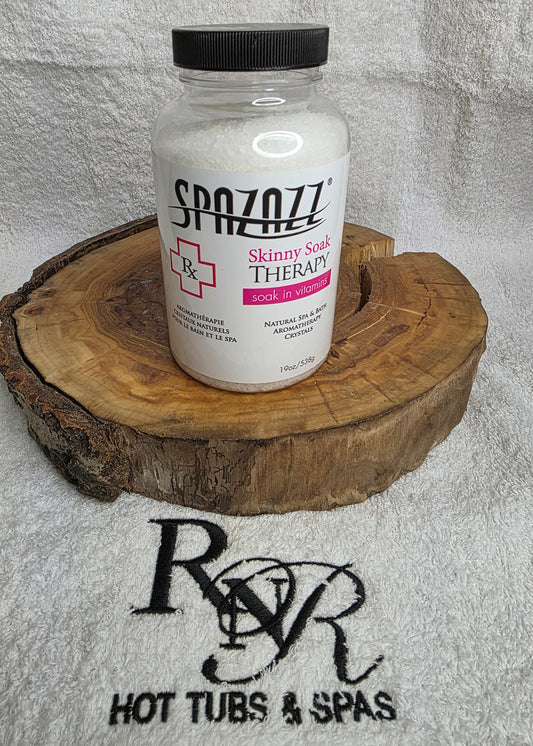Bottle of Spazazz Skinny Soak aromatherapy crystals on a wooden block with RnR Hot Tubs & Spas logo in the background