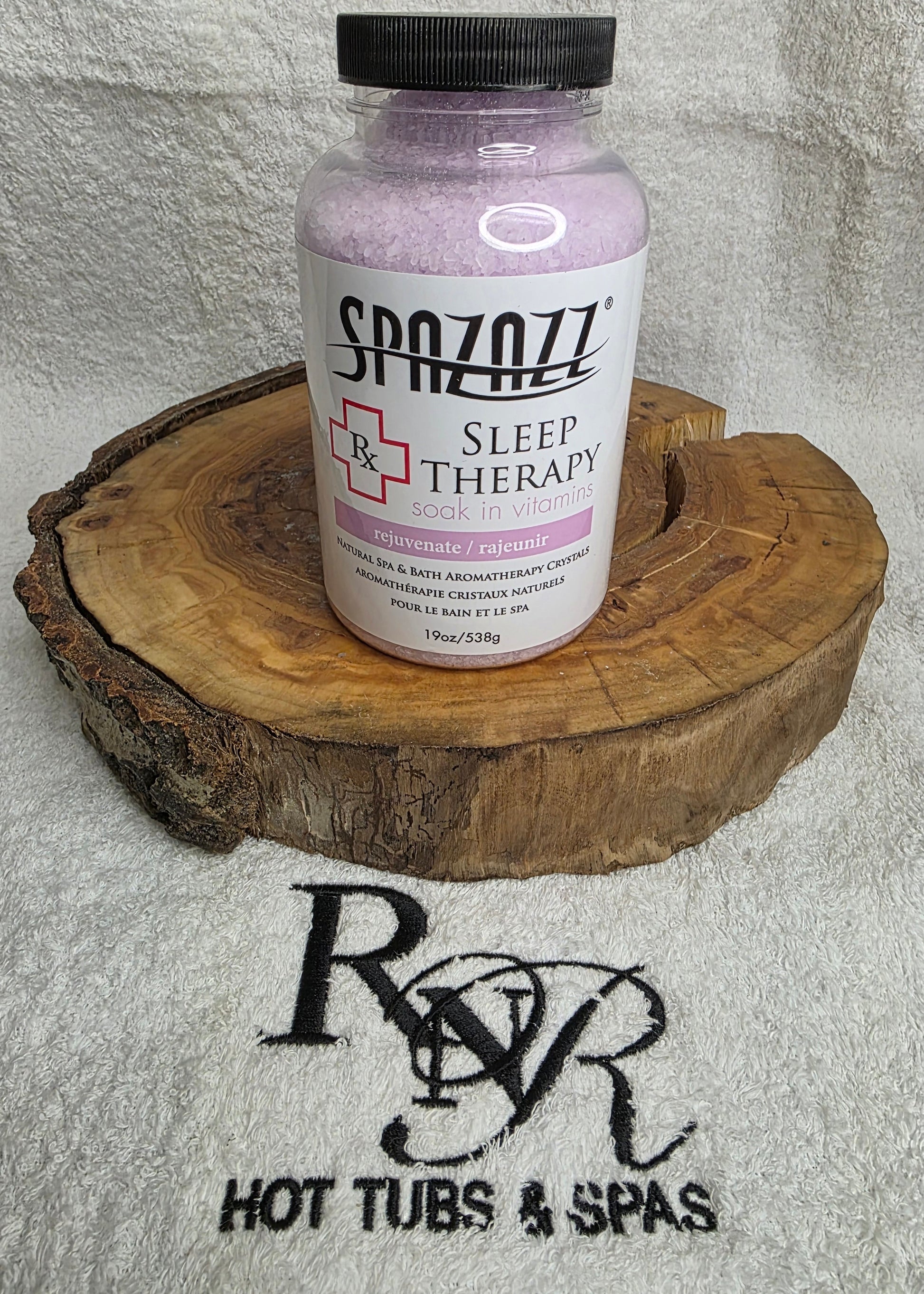 Bottle of Spazazz Sleep Therapy on a wooden block with RnR Hot Tubs & Spas logo in the background