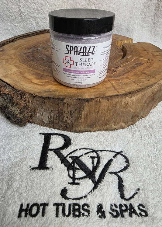 Jar of Spazazz Sleep aromatherapy crystals on a wooden block with RnR Hot Tubs & Spas branding in the background.