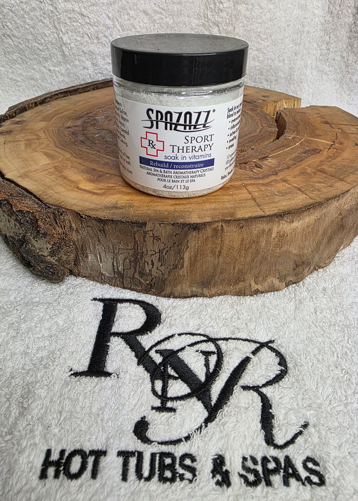 Jar of Spazazz Sport Therapy aromatherapy product on a wooden block with RnR Hot Tubs & Spas logo in the background.