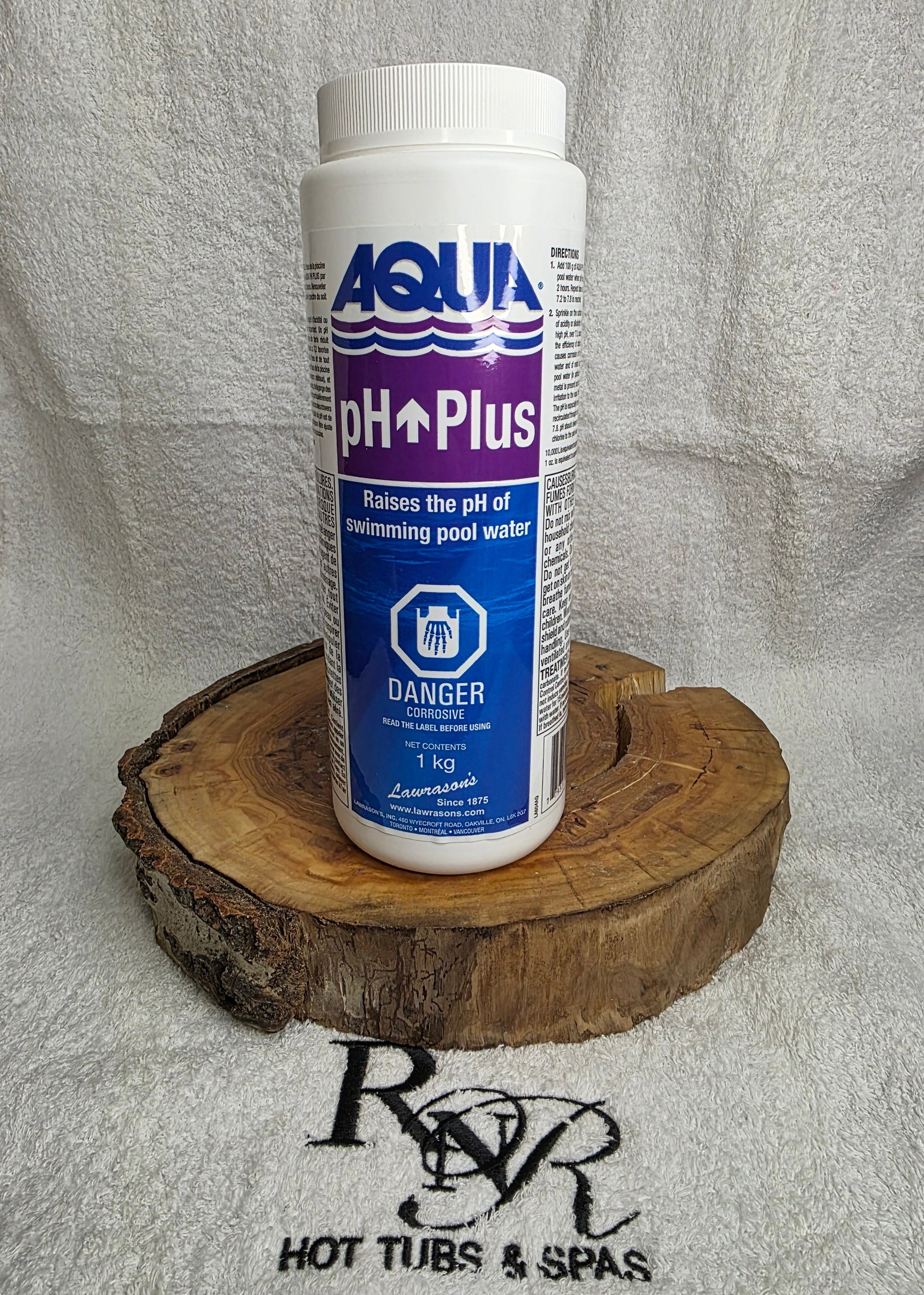 Aqua pH Plus bottle on a wooden block with a towel and RnR Hot Tubs and Spas branding in the background